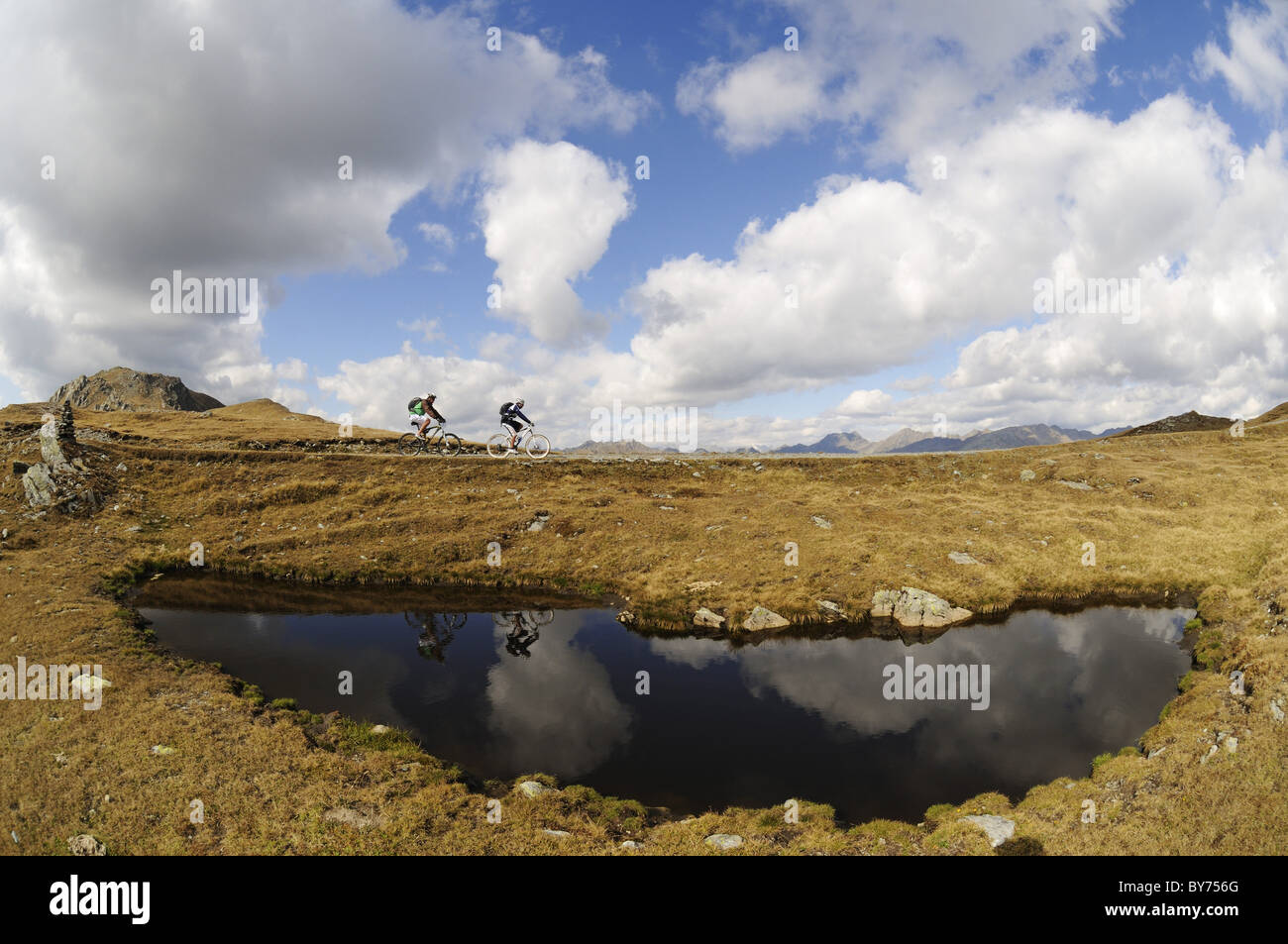 Les gens sur des vélos de montagne au lac de montagne sous ciel nuageux, Markinkele, Saint-Maurice, Val Pusteria, Dolomites, Tyrol du Sud, Italie, Banque D'Images