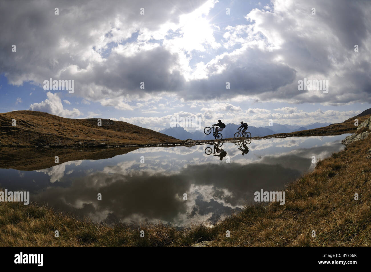 Les gens sur des vélos de montagne au lac de montagne sous ciel nuageux, Markinkele, Saint-Maurice, Val Pusteria, Dolomites, Tyrol du Sud, Italie, Banque D'Images