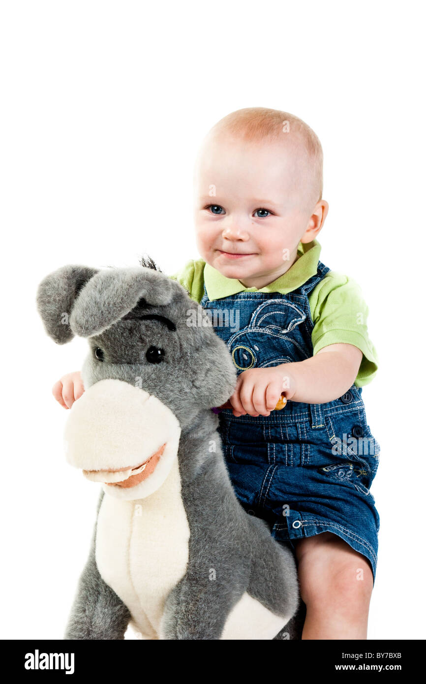 Baby Boy swinging sur un âne isolated on white Banque D'Images