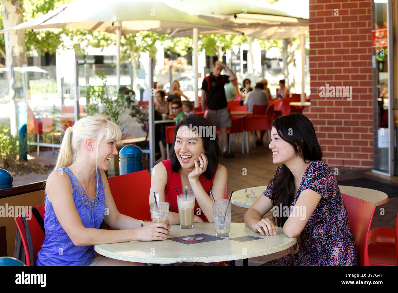 Australian girls chatting over un café glacé dans un café de la ville, en plein air, à Adelaide, Australie du Sud pendant l'été Banque D'Images