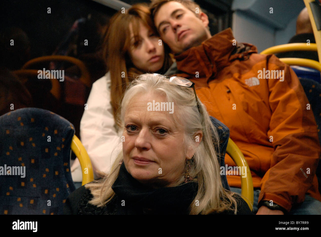 Femme d'âge moyen sur le bus avec couple derrière Banque D'Images