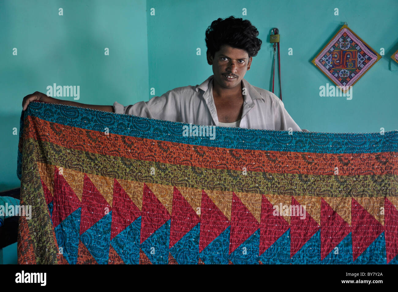 Un homme de Kutch, Gujarat montrant son travail de broderie sur le drap de lit Banque D'Images