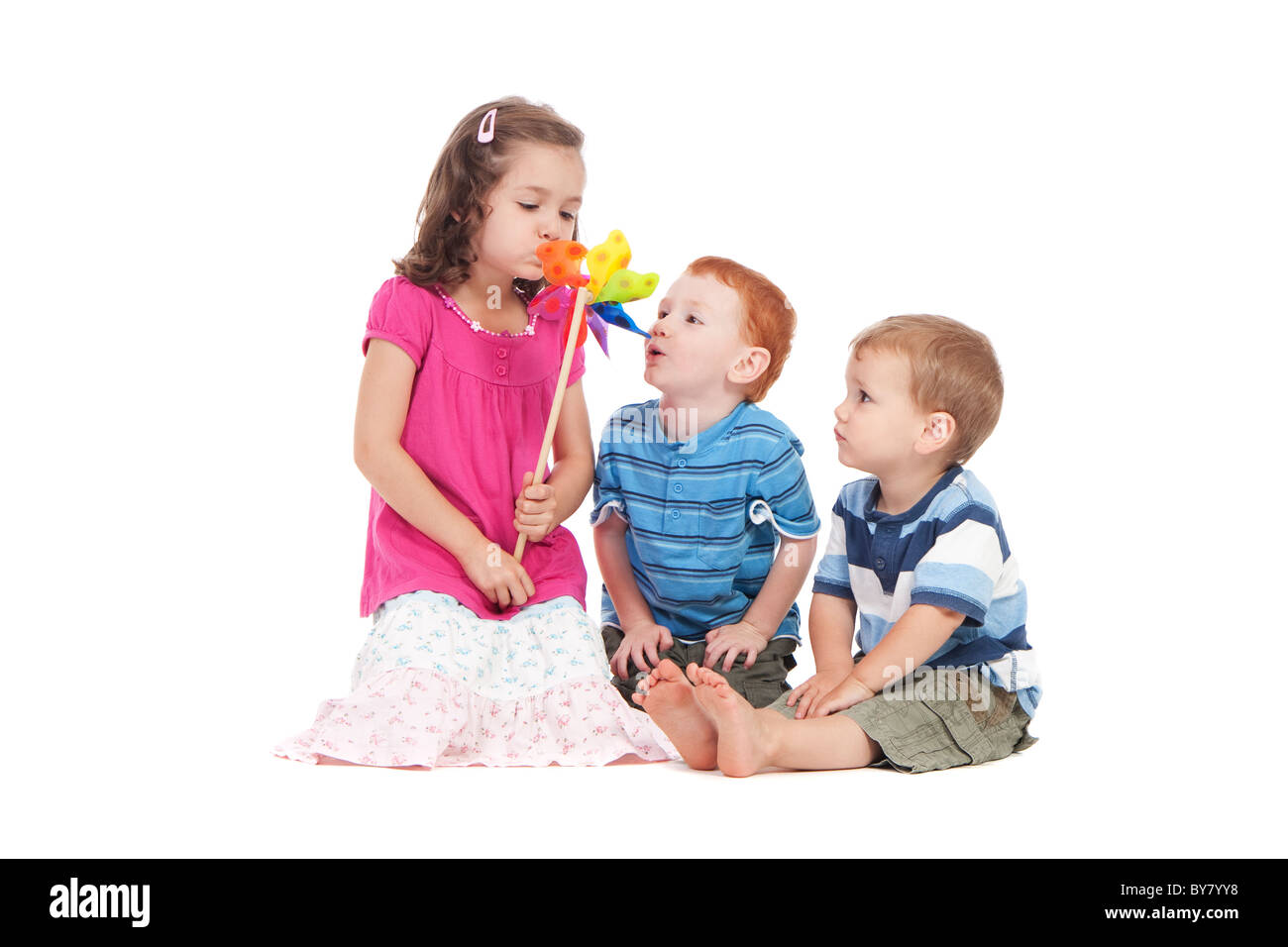 Trois enfants jouet moulin de soufflage. Isolé sur blanc. Banque D'Images