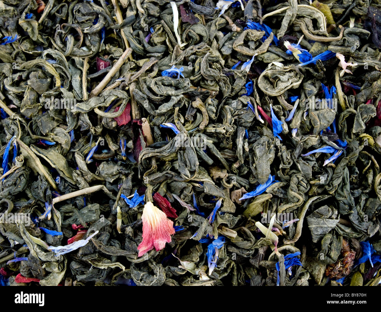 Feuilles de thé vert aromatiques d'hibiscus et de pétales de bleuet sur fond blanc Banque D'Images