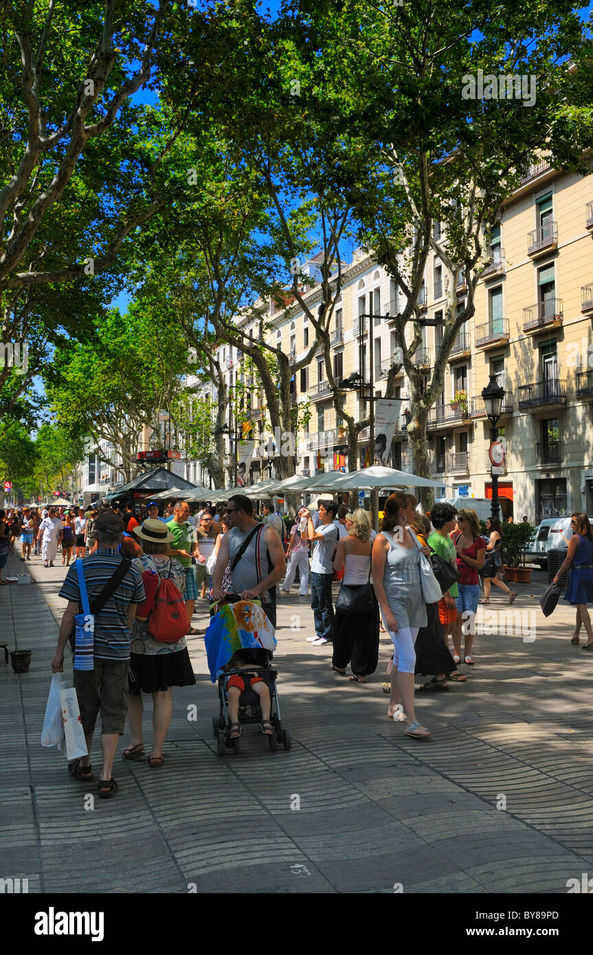 Les touristes et habitants de profiter de l'ombre protectrice des arbres à La Rambla (section Rambla de Santa Mònica), Barcelone, Espagne. Banque D'Images