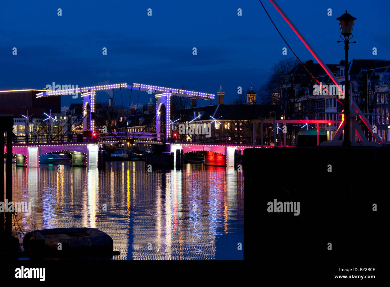 Le Magere Brug ou Skinny Bridge Amsterdam est un célèbre monument. Sur la rivière Amstel au crépuscule en hiver avec illumination festive Banque D'Images