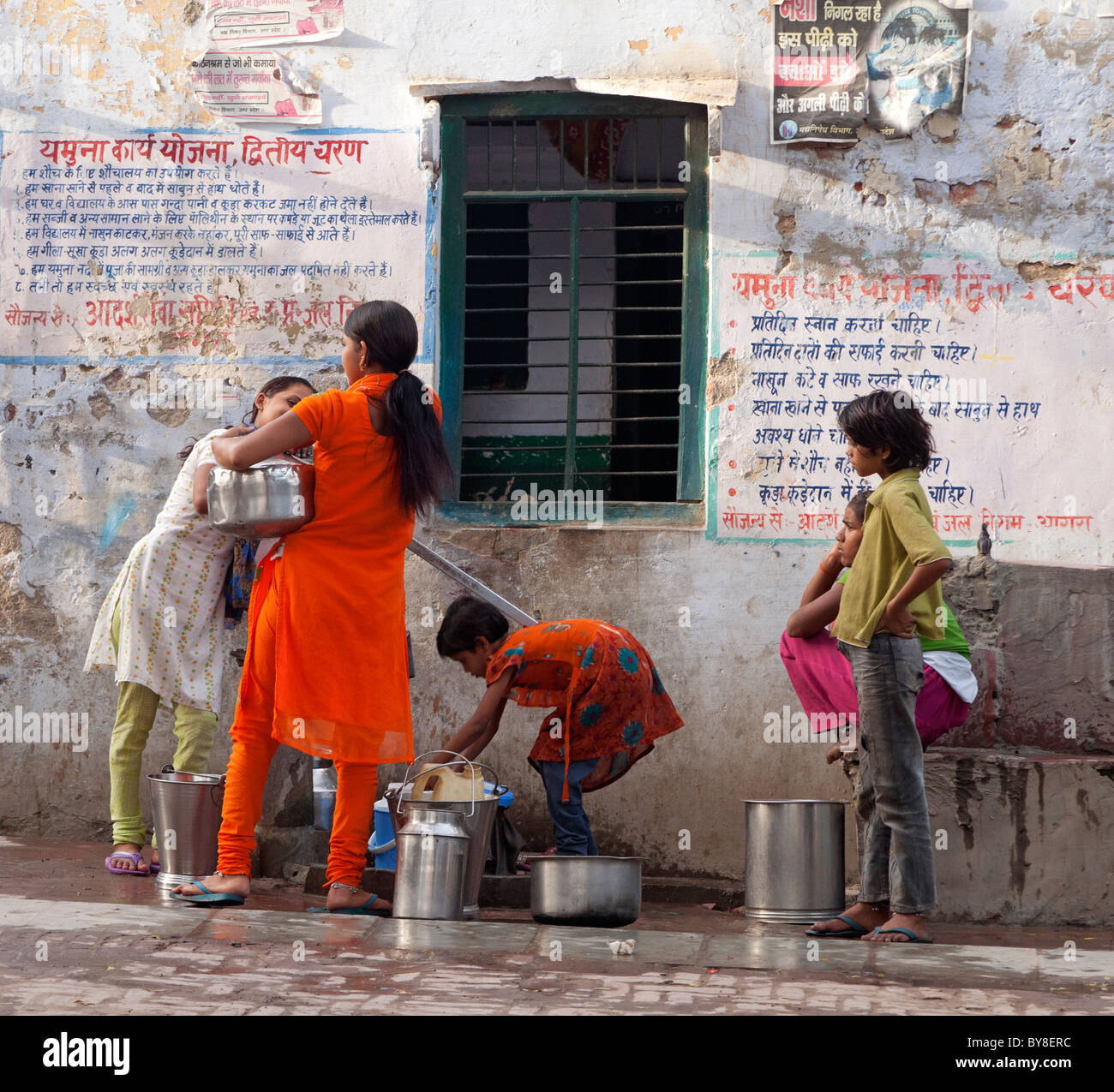 L'Inde, Uttar Pradesh, Agra, les adolescentes à la collecte de l'eau de la pompe du village Banque D'Images