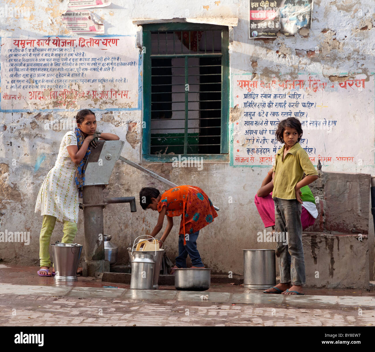 L'Inde, Uttar Pradesh, Agra, les adolescentes à la collecte de l'eau de la pompe du village Banque D'Images