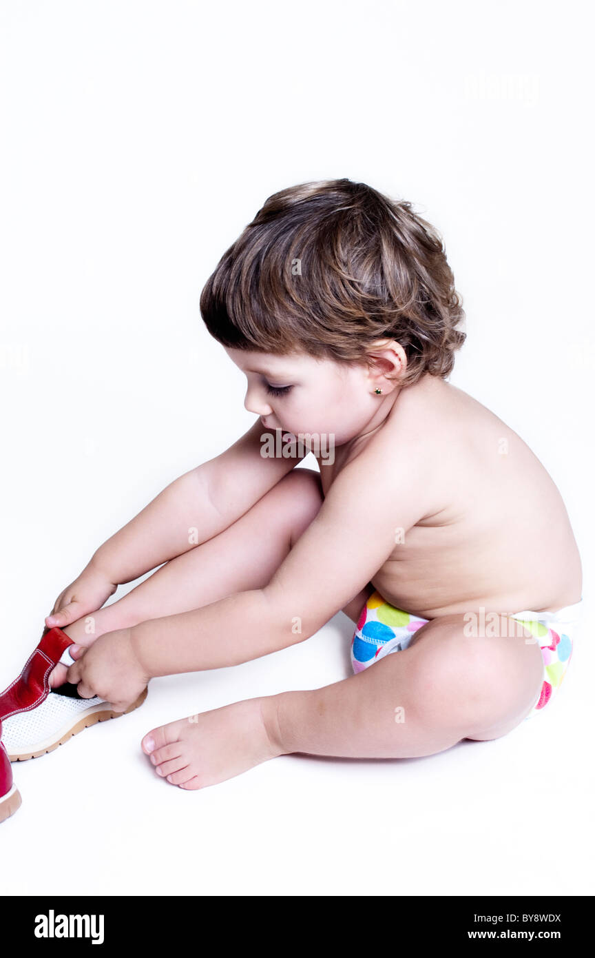 Couches bébé en essayant de mettre ses chaussures Banque D'Images