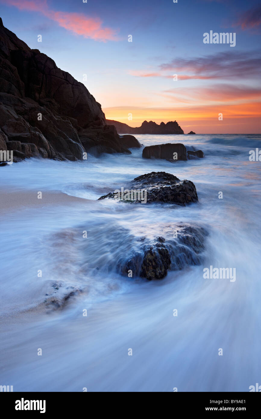 Flux de marée de la marée montante poussant à terre et sur des pierres à plage de Porthcurno, Cornwall Banque D'Images