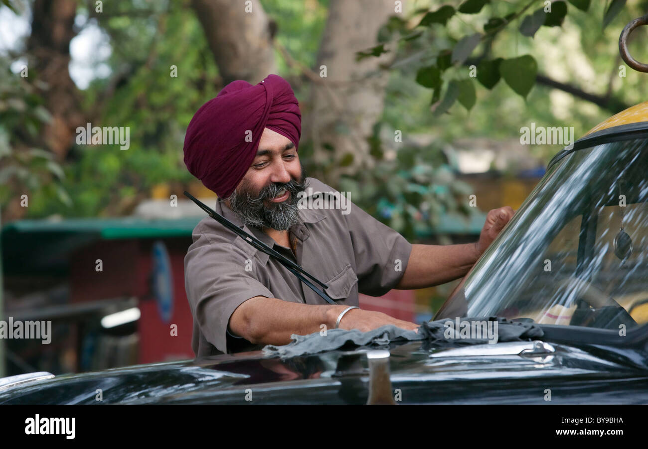 Chauffeur de taxi sikh son véhicule de nettoyage Banque D'Images