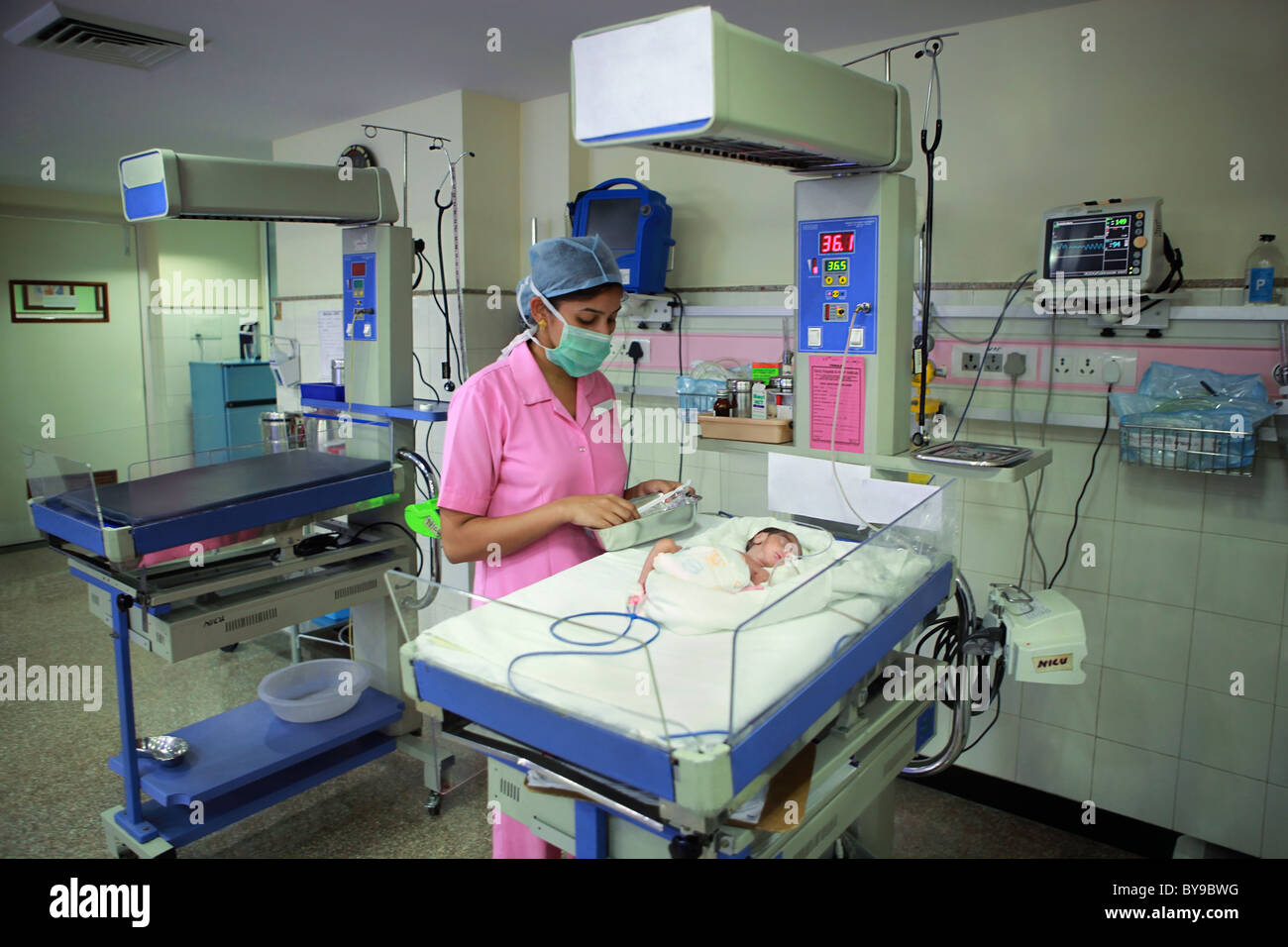 Nurse tending to newborn baby in hospital nursery Banque D'Images