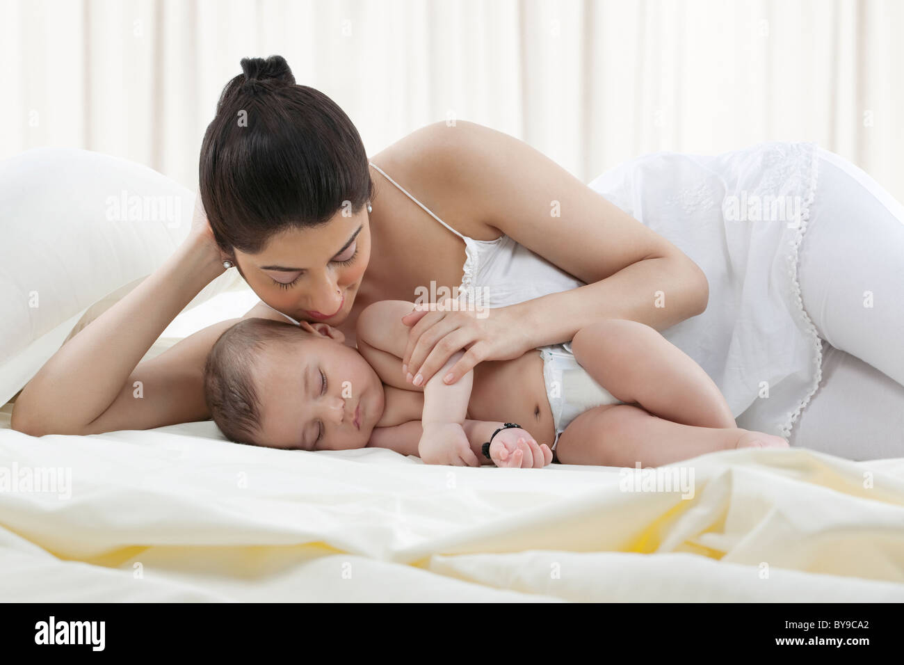 Mère regardant son bébé dormir Banque D'Images