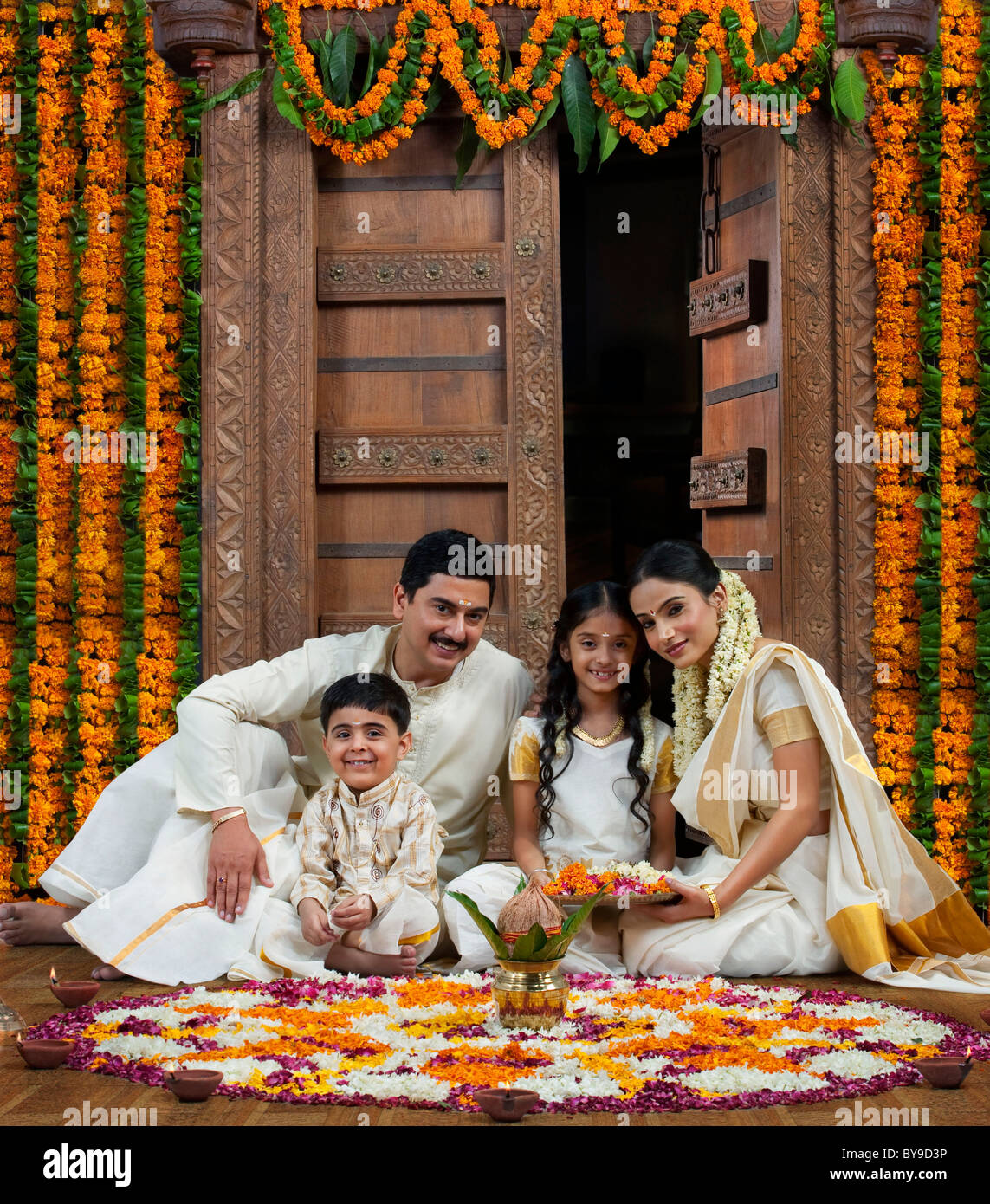 La famille du sud de l'Inde avec fleur rangoli Banque D'Images