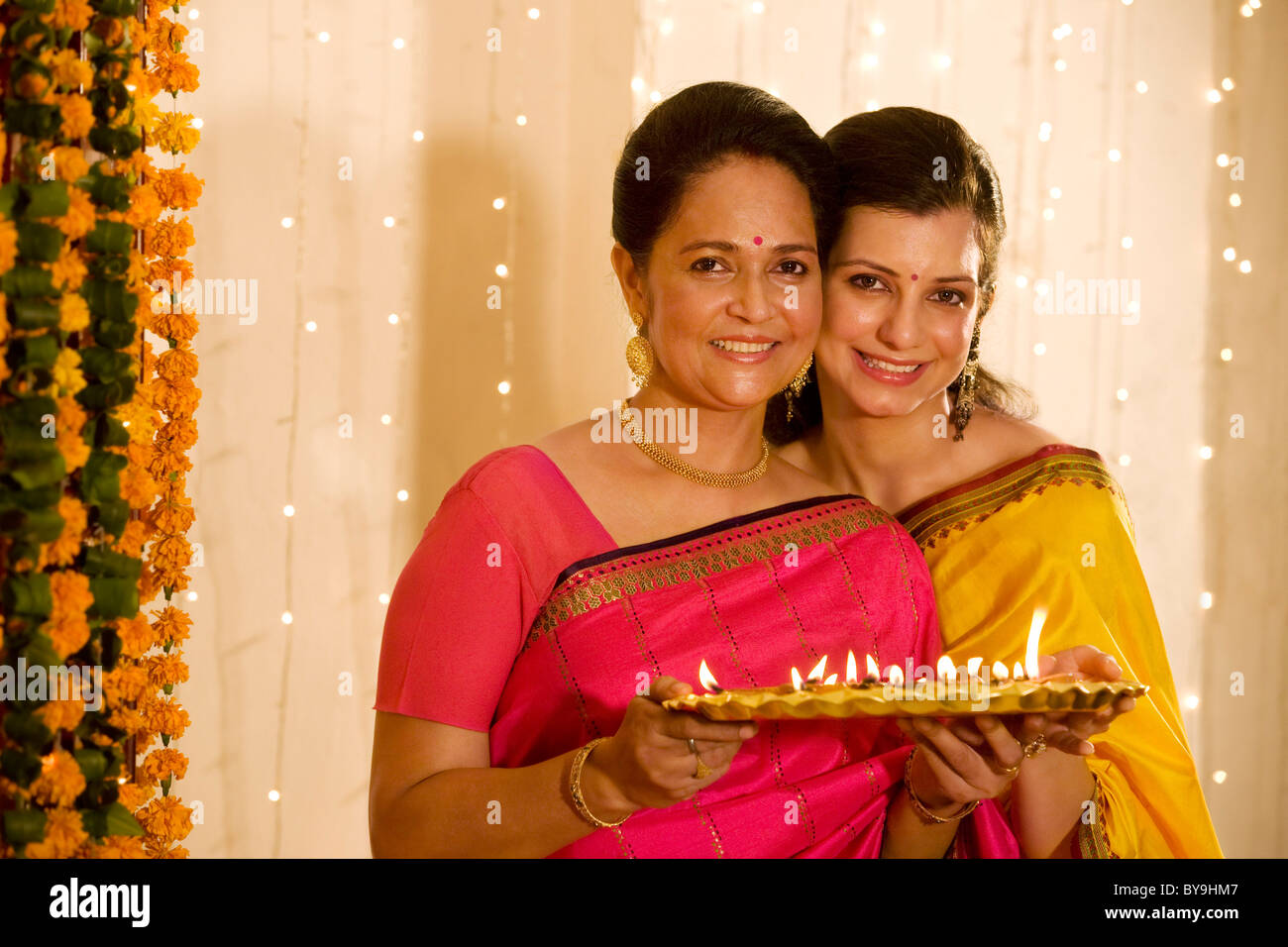 Mère et fille holding a tray de diyas Banque D'Images
