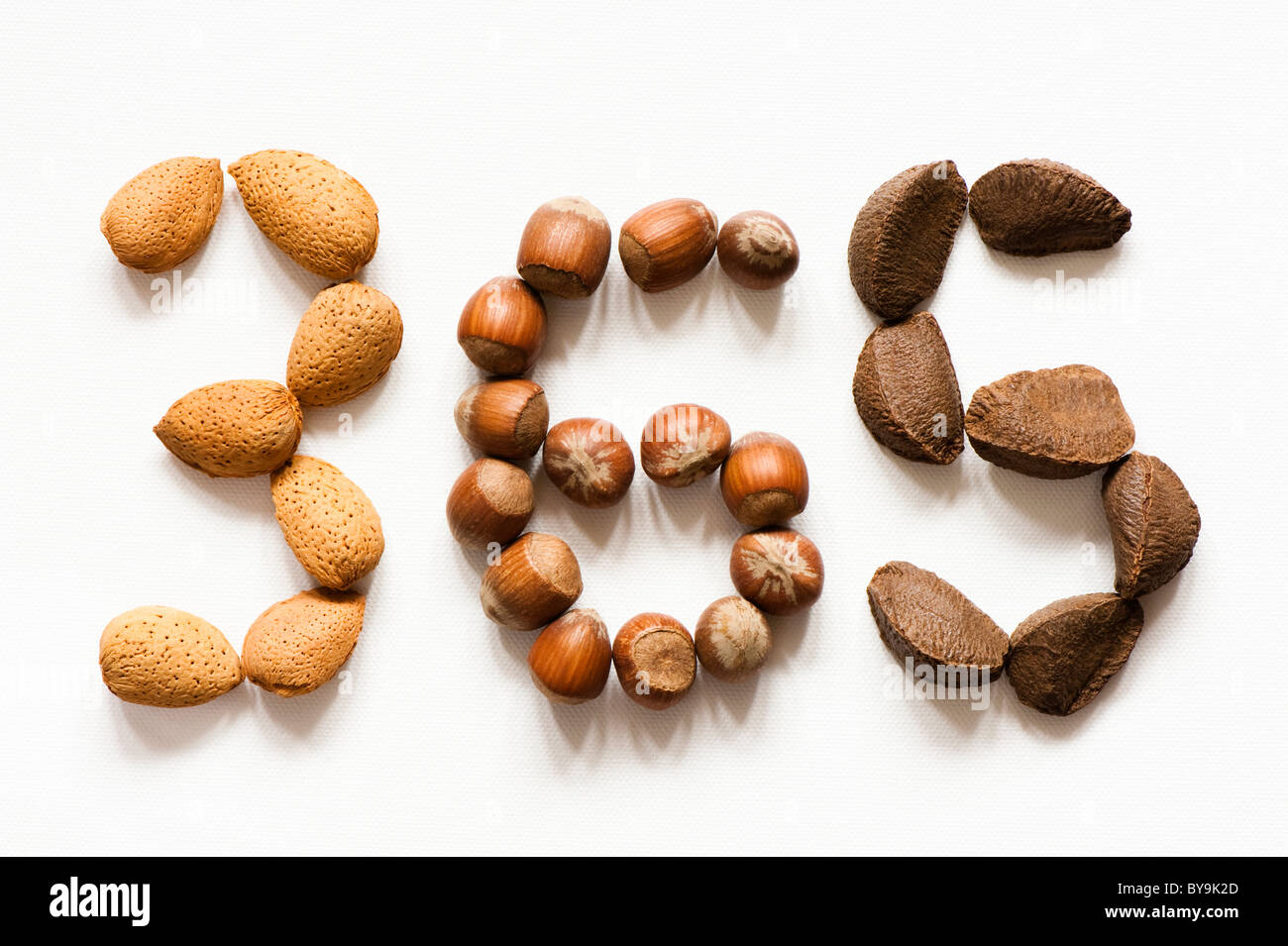 Les amandes, les noisettes et les noix du Brésil établi sur un fond blanc dans les chiffres 3, 6 et 5 Banque D'Images