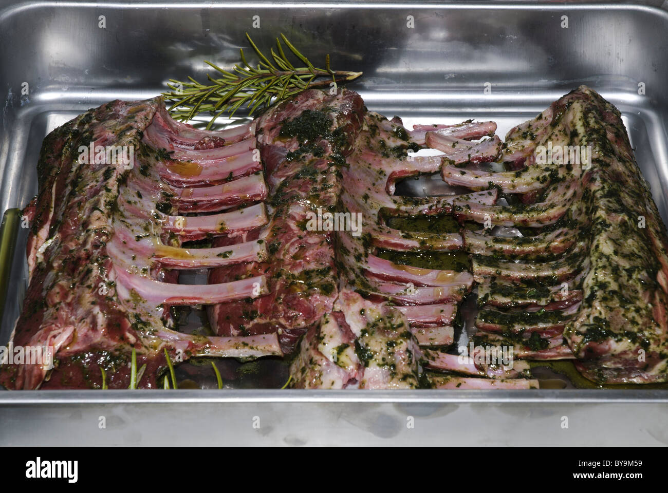 Côtelettes d'agneau assaisonné de racks sur une plaque de cuisson Banque D'Images