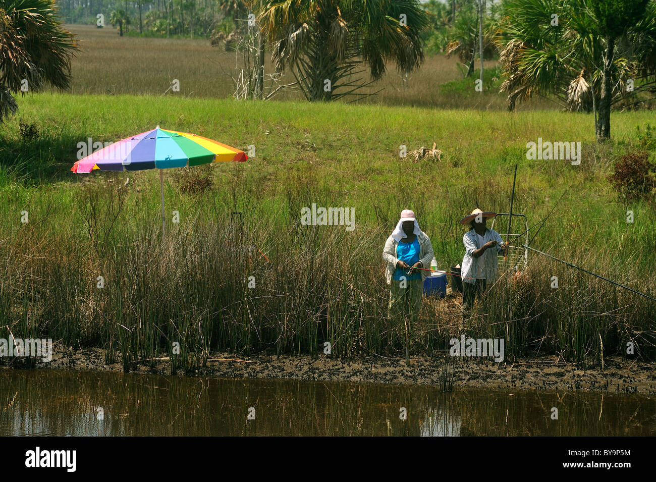 Deux femmes afro-américaines de pêcher sur un étang marécageux dans le fleuve marque Wildlife Refuge dans la région de Big Bend de Floride Nord Banque D'Images