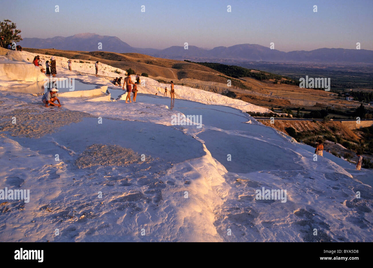 Les touristes à la sources chaudes de Pamukkale, Turquie au crépuscule / coucher du soleil. Banque D'Images