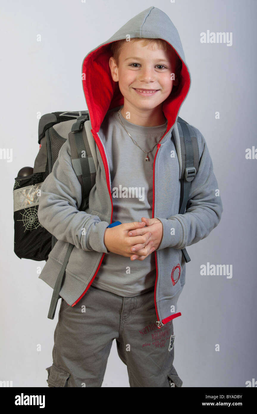 6 ans avec un sac d'école portant un sweat à capuche, première année d'école des enfants Banque D'Images