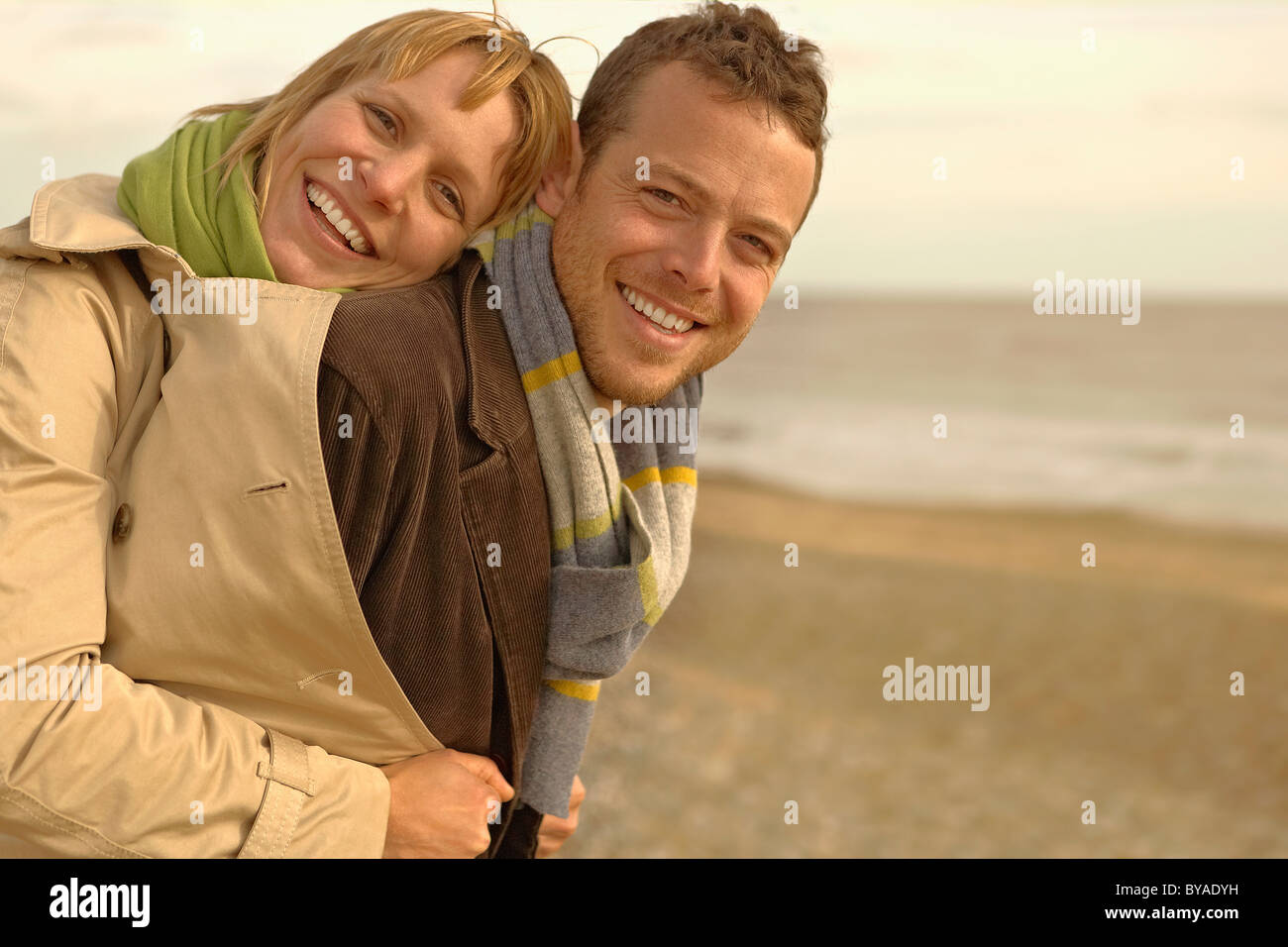 Woman embracing man par derrière on beach Banque D'Images