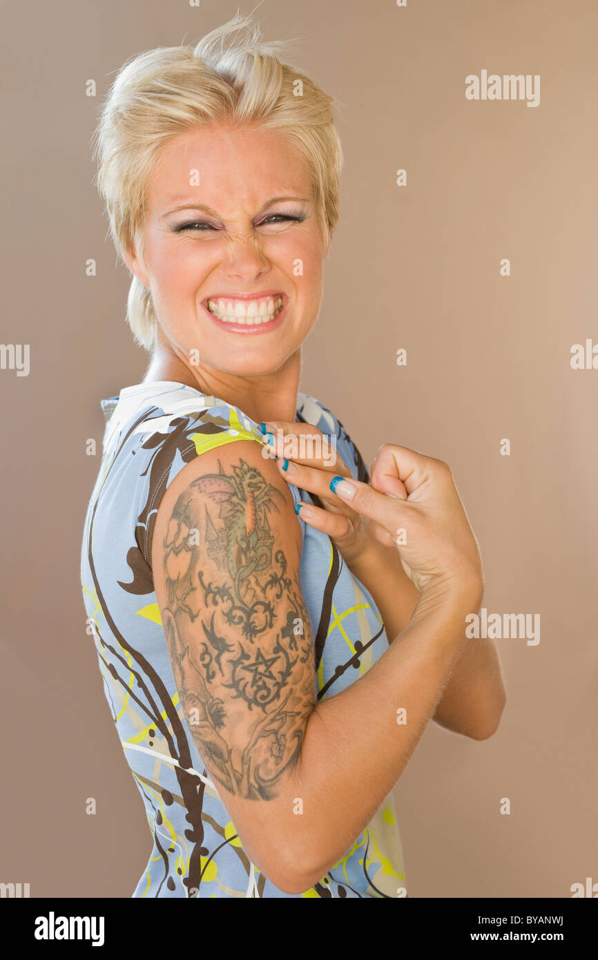 Belle fille montrant tattoo sur bras Banque D'Images