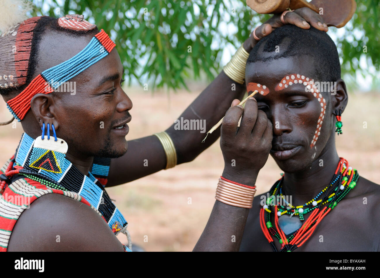 Les hommes de la tribu Hamar chaque peinture d'autres pour le rituel d'initiation 'leap sur le bétail', le sud de la vallée de l'Omo, Ethiopie Banque D'Images