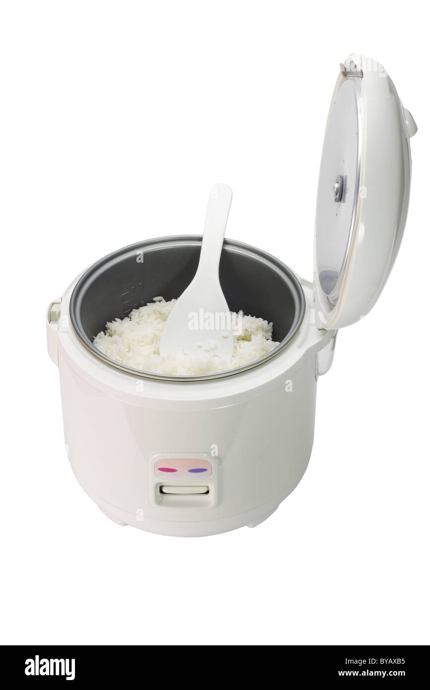 Le riz cuit au four électrique avec cuillère en plastique sur fond blanc Banque D'Images