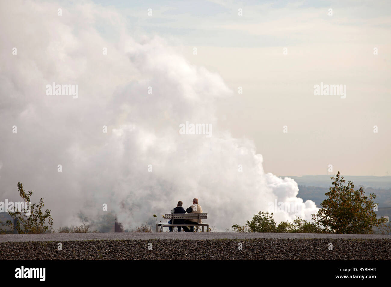 Couple sur un banc en face de la pollution d'une centrale à Bottrop, Ruhr, Rhénanie du Nord-Westphalie Banque D'Images