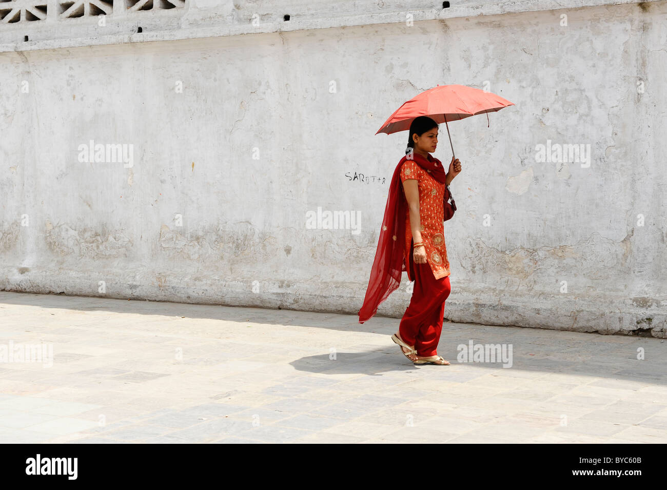 Dame népalaise de prendre une marche, holding umbrella pour l'ombre du soleil , la vie des populations ( l ) les Népalais, Katmandou, Népal Banque D'Images