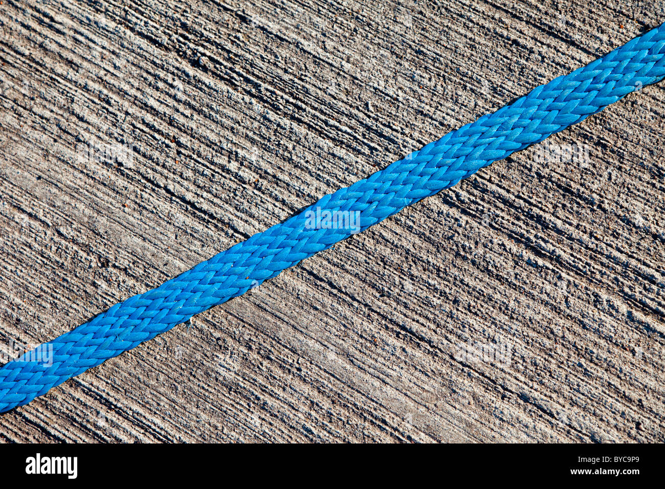 Corde bleue en nylon sur une surface en béton rugueux Banque D'Images Corde bleue en nylon sur une surface en béton rugueux Banque D'Images