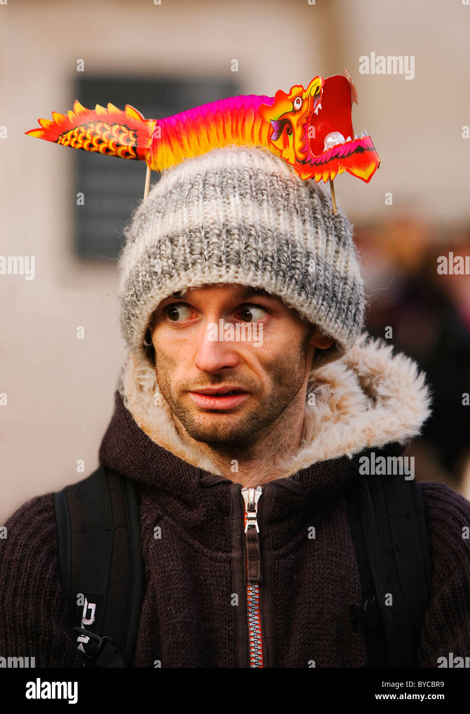 Jeune homme posant avec un dragon de papier sur la tête. Les célébrations du Nouvel An chinois, Trafalgar Square, Londres, Royaume-Uni, Europe Banque D'Images