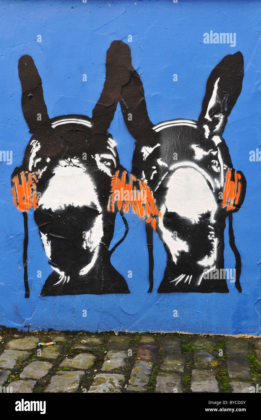 Graffiti pochoir à Bristol en Angleterre illustrant les ânes listening to music on headphones Banque D'Images