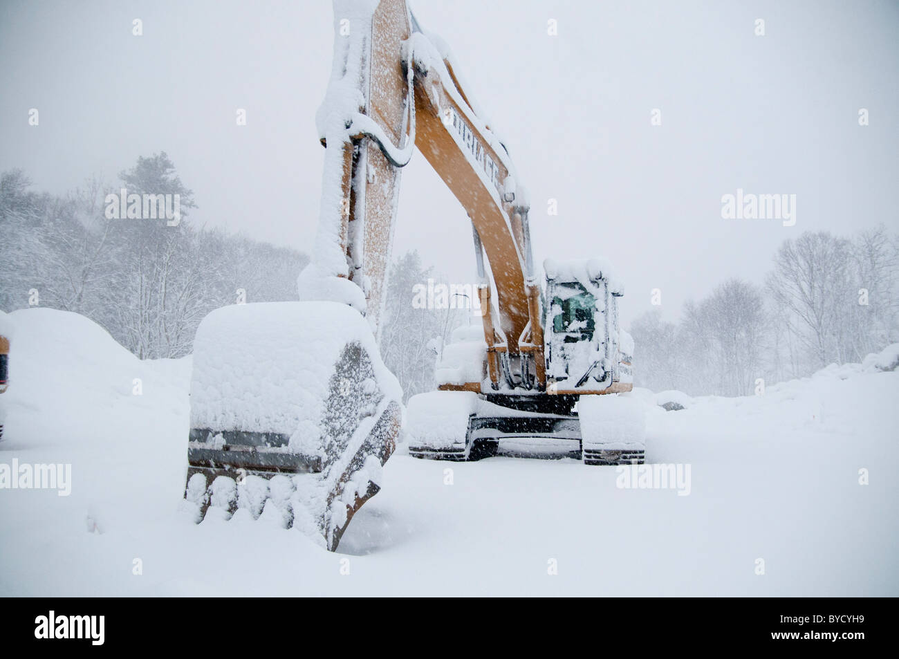 Un chargeur avant se trouve sur un chantier de construction non utilisés pendant un blizzard à Wakefield, MA Banque D'Images