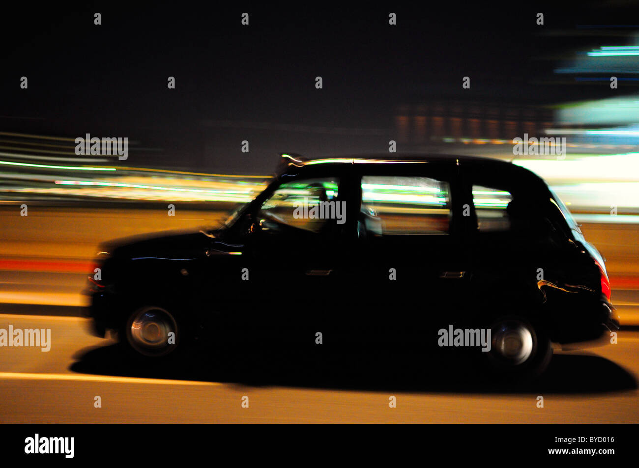 Black Taxi Cab se déplaçant dans les rues de Londres la nuit avec motion blur Banque D'Images