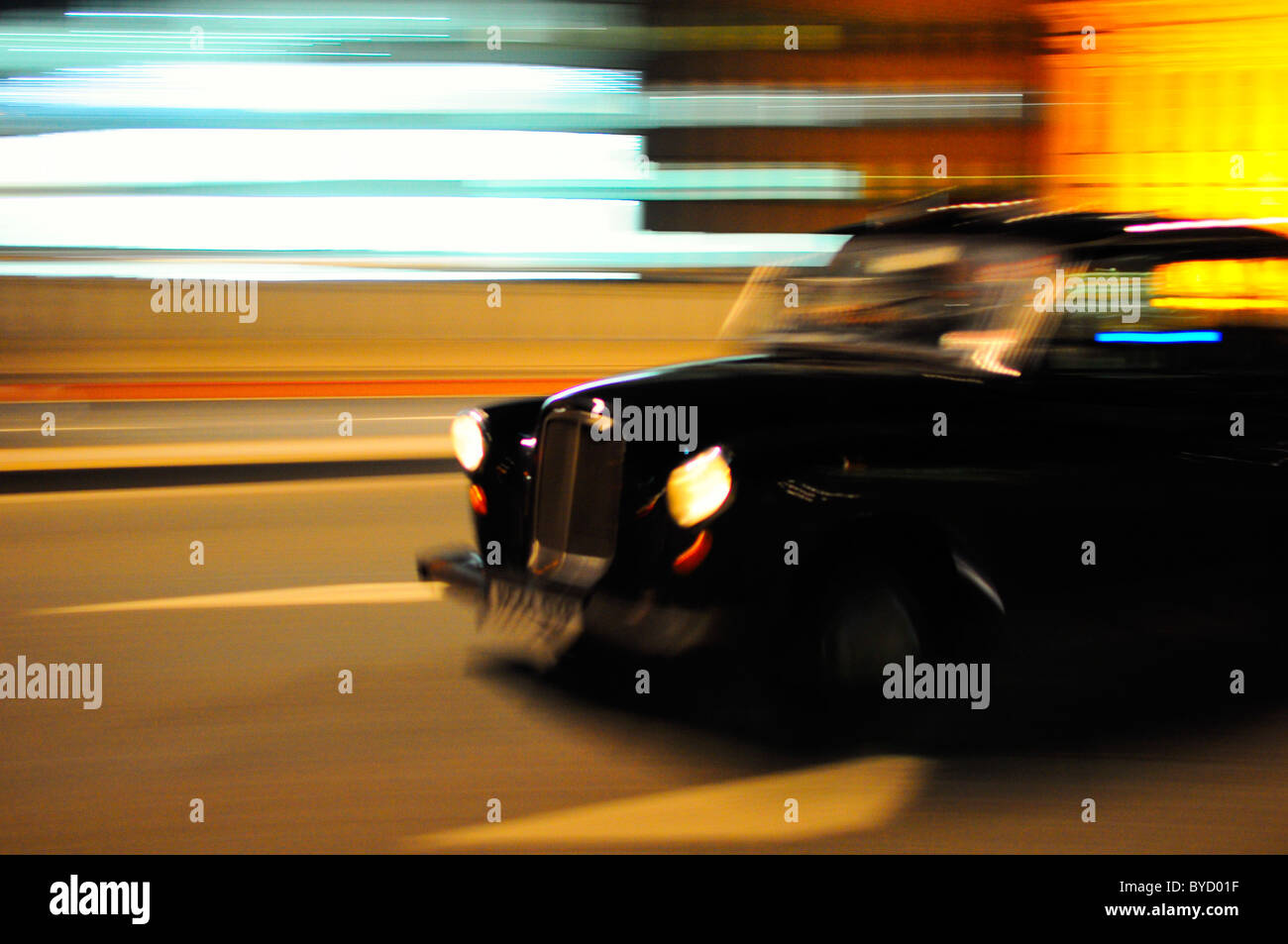 Black Taxi Cab se déplaçant dans les rues de Londres la nuit avec motion blur Banque D'Images