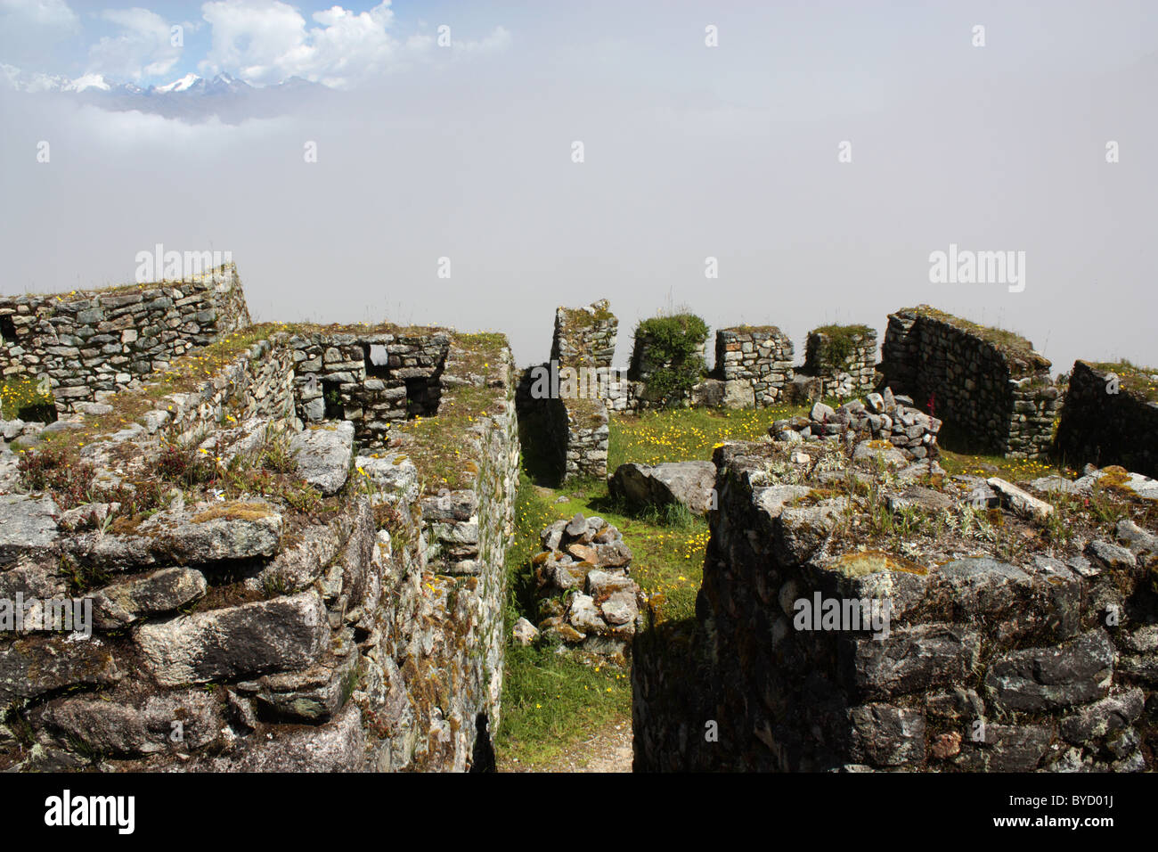 Les ruines Inca de Sayacmarca au Pérou avec le Vilcabamba visible au-dessus des nuages Banque D'Images