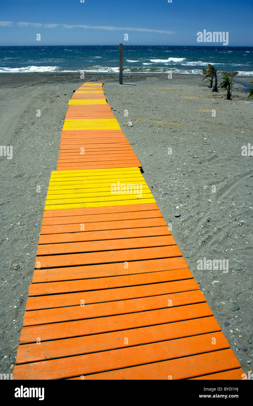 Jaune et orange-conseil à pied dans le sable sur la plage de Torrox Costa, Costa del Sol, Andalousie, Espagne, de la Méditerranée, Banque D'Images