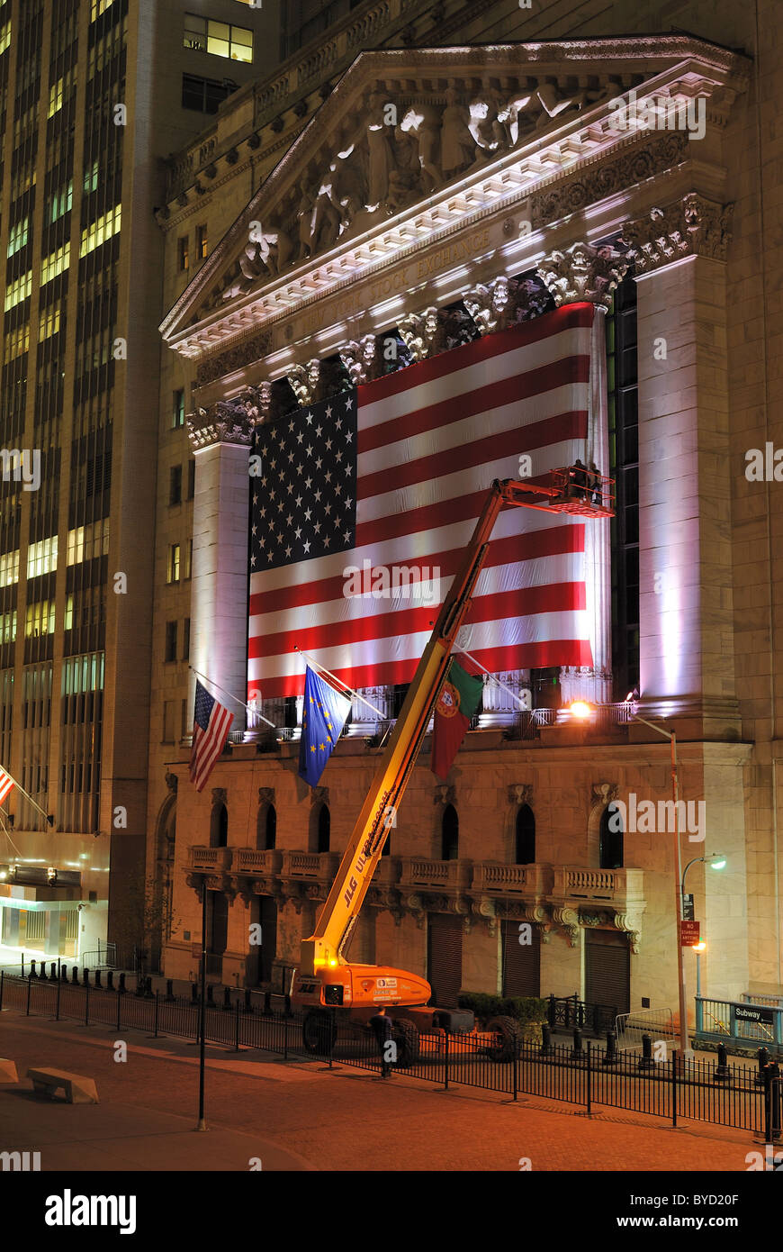 Crane et les travailleurs de mettre en place les grands drapeaux à la Bourse de New York à New York. Le 26 mai 2010. Banque D'Images