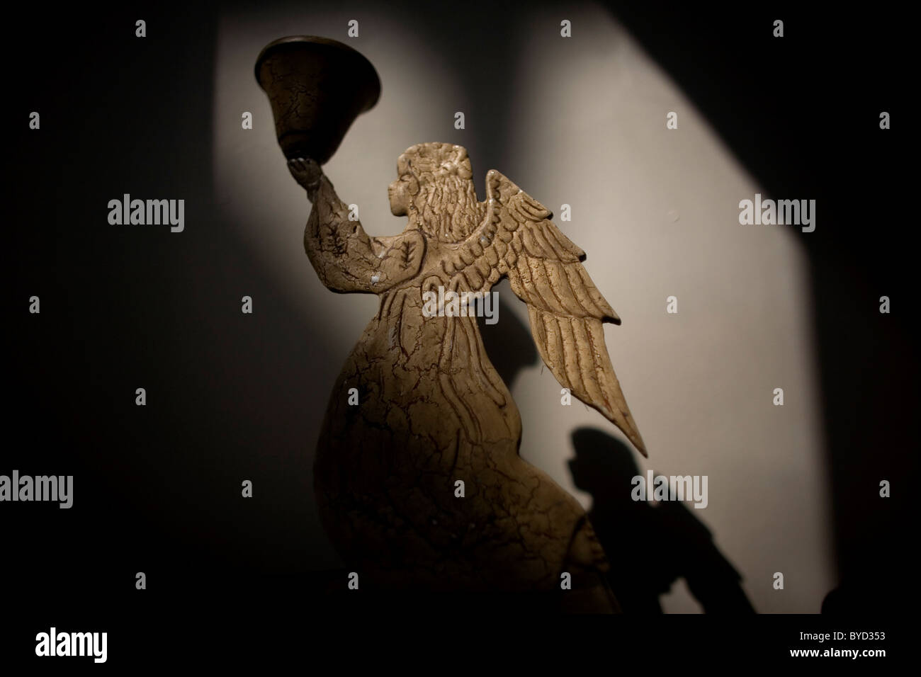 Un ange bougeoir jette une ombre sur le mur de la ville de Mexico, le 1er janvier 2011. Banque D'Images