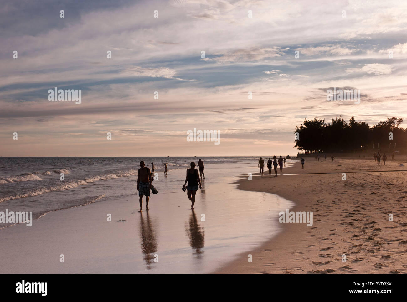 Les gens se promener le long de la plage au coucher du soleil, Mui Ne, Vietnam Banque D'Images