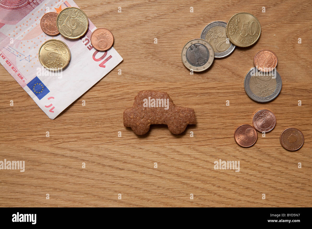 Pièces de voiture à côté de biscuit et d'un billet Banque D'Images