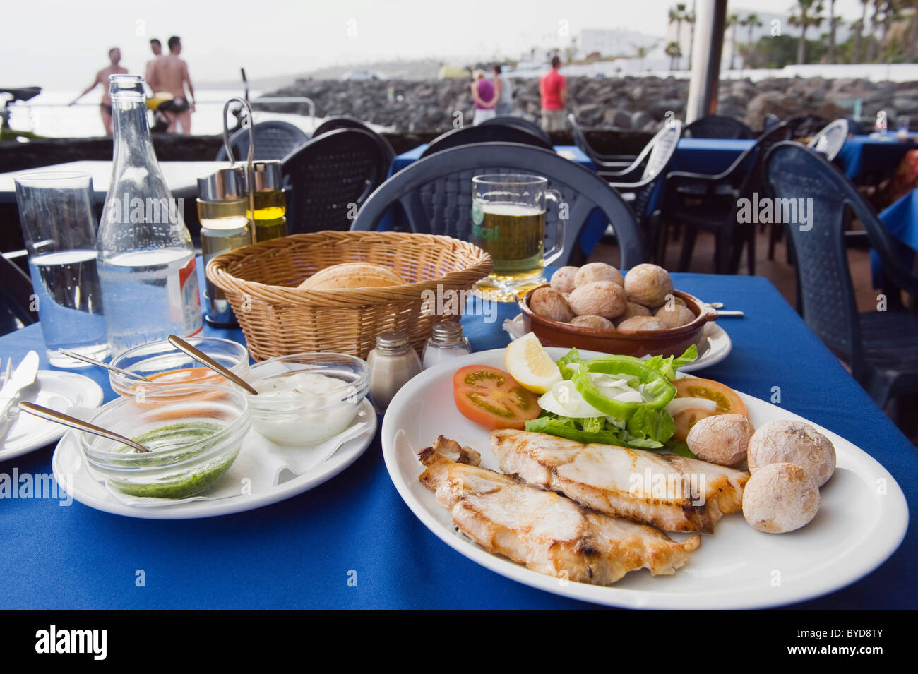 La cuisine espagnole dans le restaurant, le poisson grillé avec pommes de terre des Canaries, Papas arrugadas, Mojo Rojo, source Mojo Verde Banque D'Images