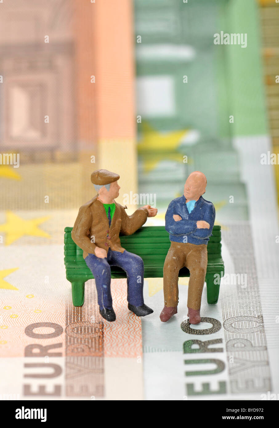 Figures miniatures de personnes âgées sur un banc de parc sur divers billets, image symbolique pour pension et retraite Banque D'Images