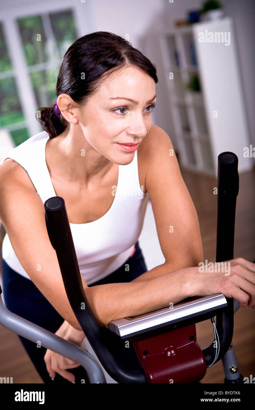 Femme sur l'entraîneur elliptique Banque D'Images