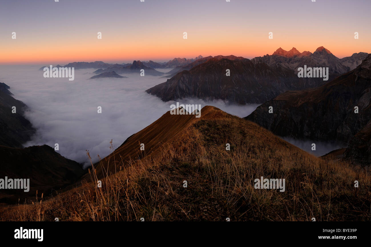 Mountain Valley sous le brouillard avec des pics de montagne dans la lumière du soir, Alpes Allgaeu, vallée de Kleinwalsertal, Vorarlberg, Autriche Banque D'Images