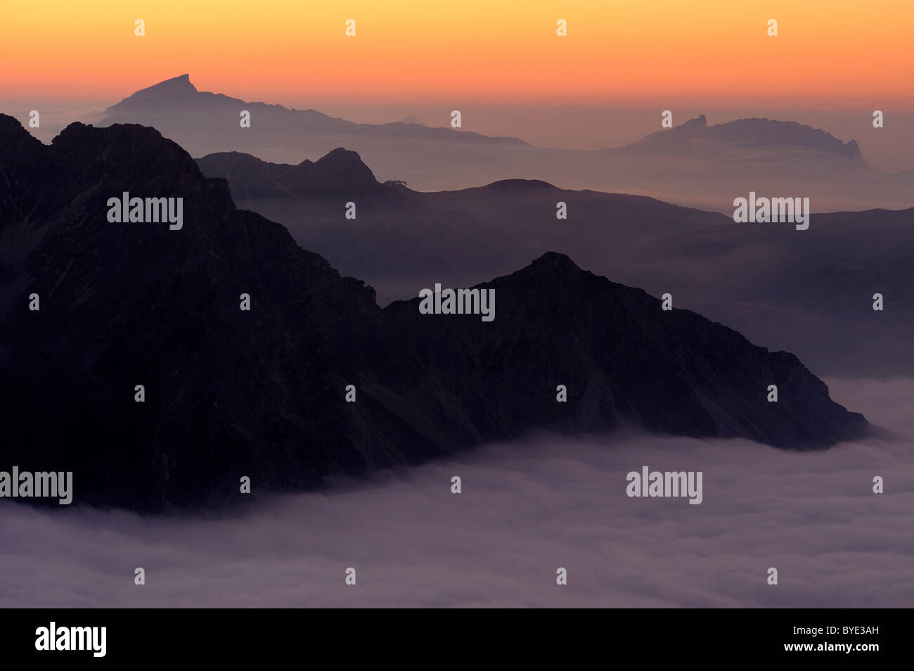 Mountain Valley sous le brouillard avec des pics de montagne dans la lumière du soir, Alpes Allgaeu, vallée de Kleinwalsertal, Vorarlberg, Autriche Banque D'Images