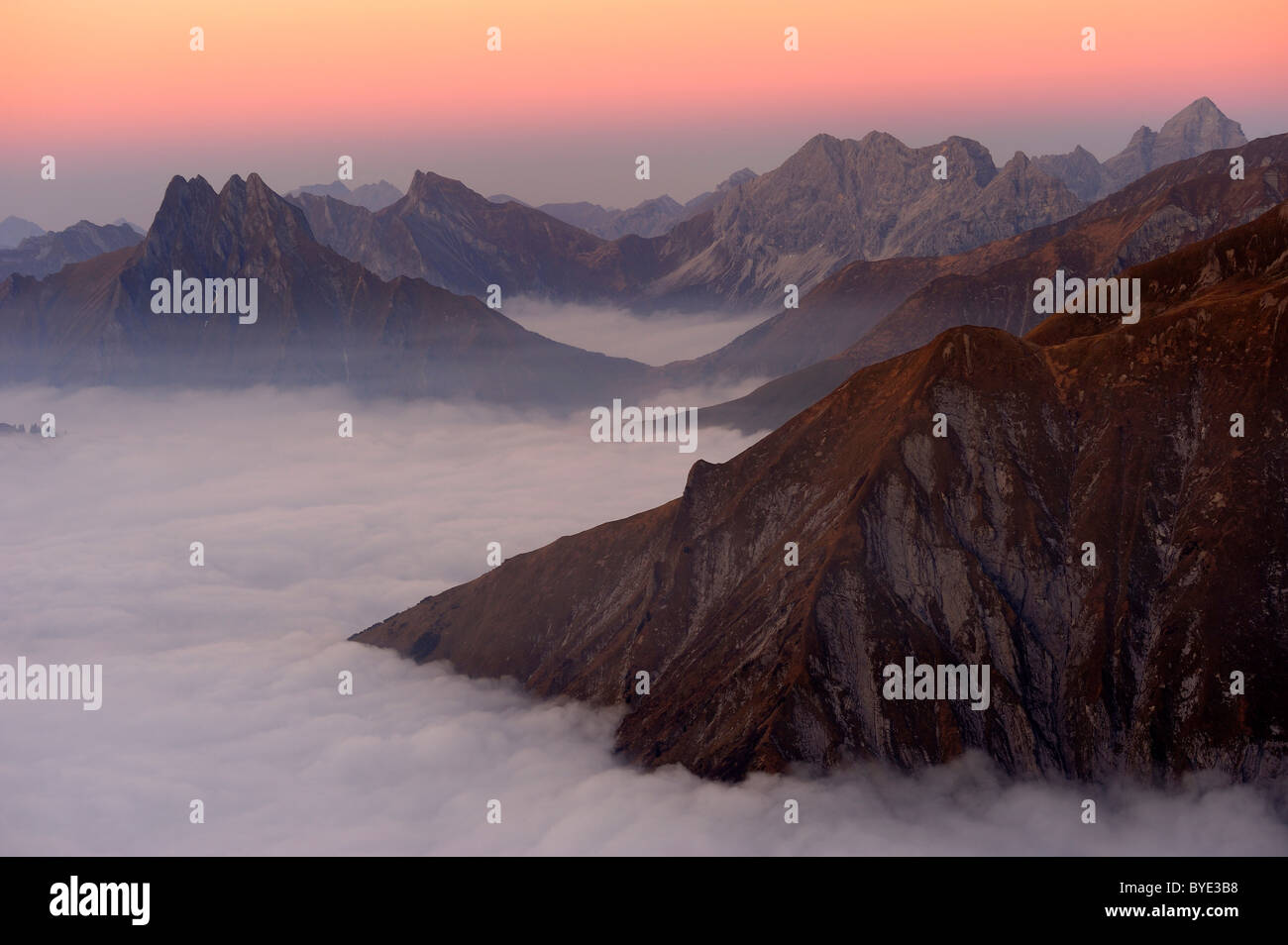 Mountain Valley sous le brouillard avec des pics de montagne dans la lumière du soir, Alpes Allgaeu, vallée de Kleinwalsertal, Vorarlberg, Autriche Banque D'Images