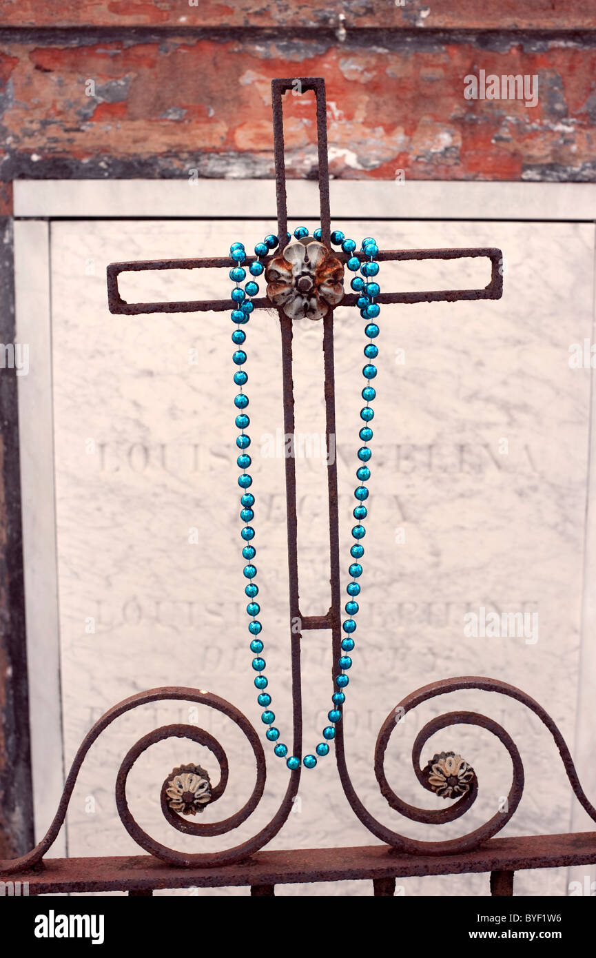 Perles bleues se suspendre à une croix dans un cimetière. Banque D'Images