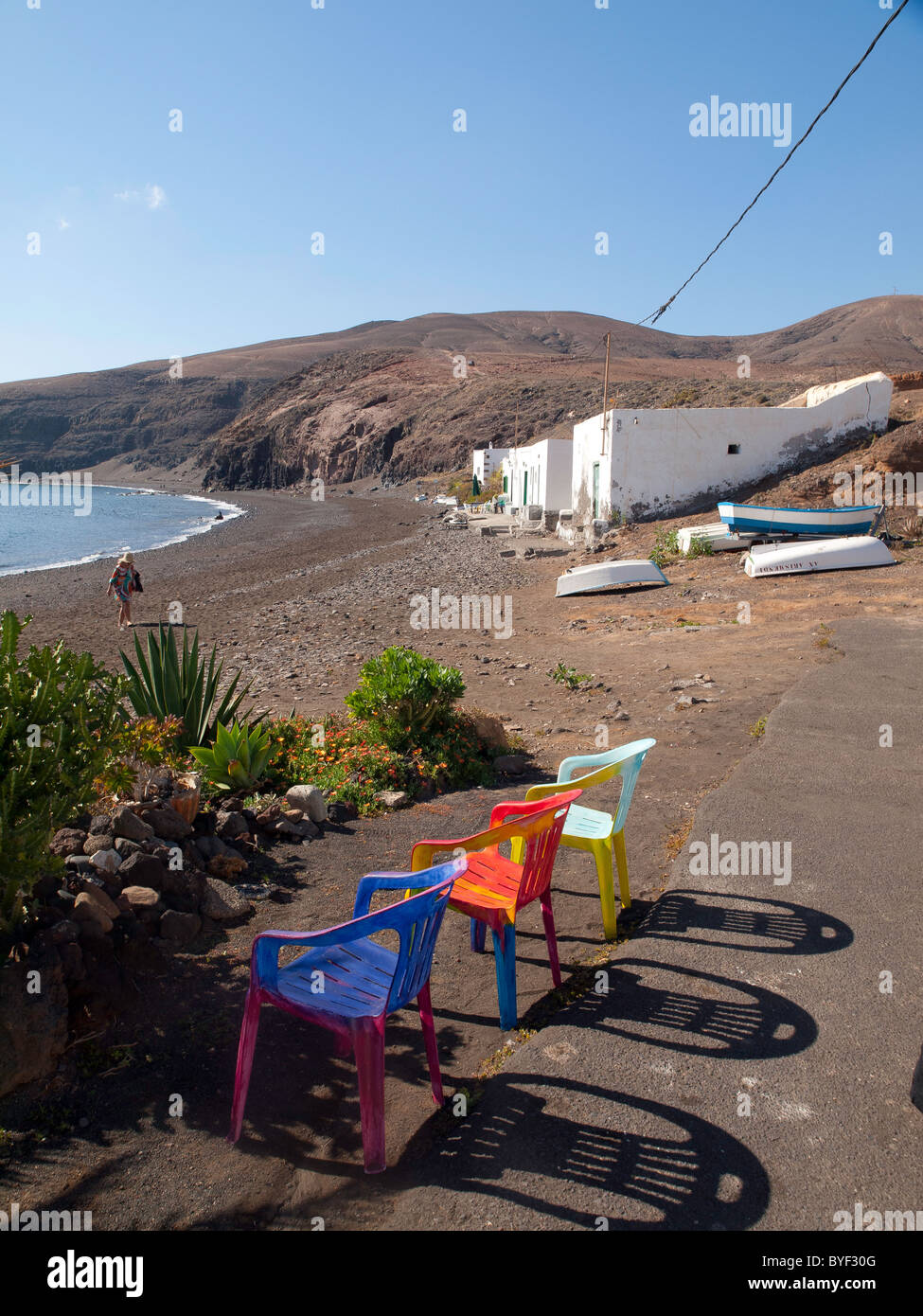 La plage dans le petit village de Playa Quemada Lanzarote avec trois chaises pour prendre le soleil Banque D'Images